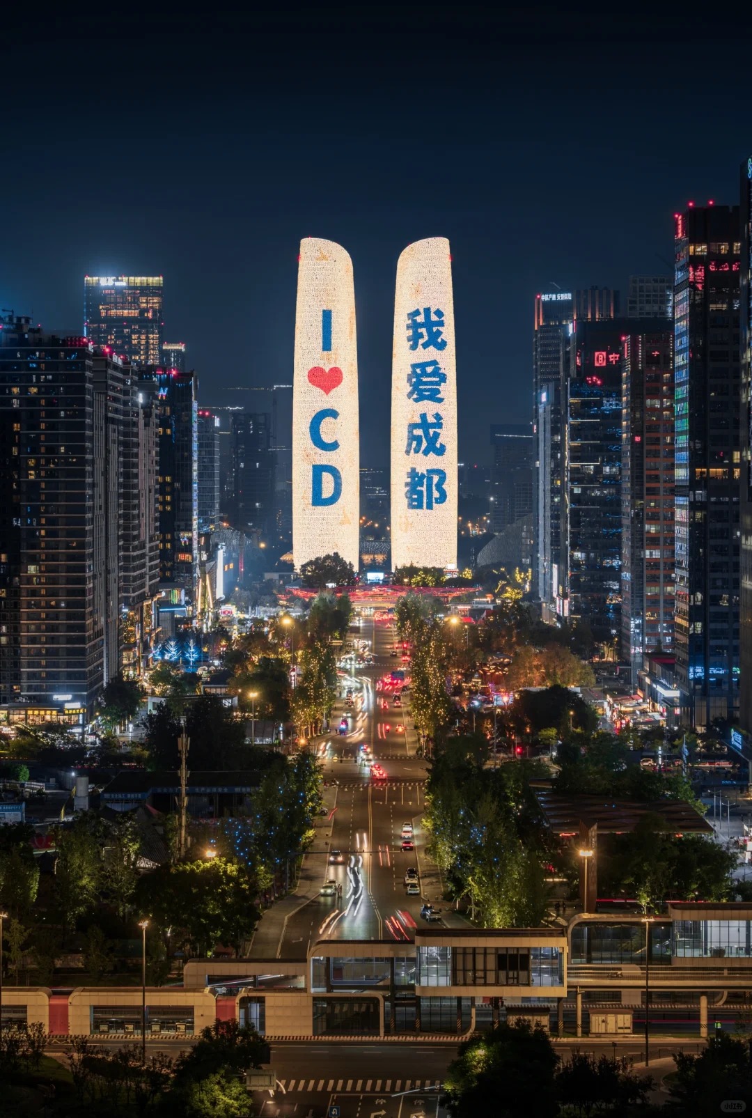 Night view of Chengdu with twin towers lit up displaying 'I ❤️ CD' and '我爱成都'